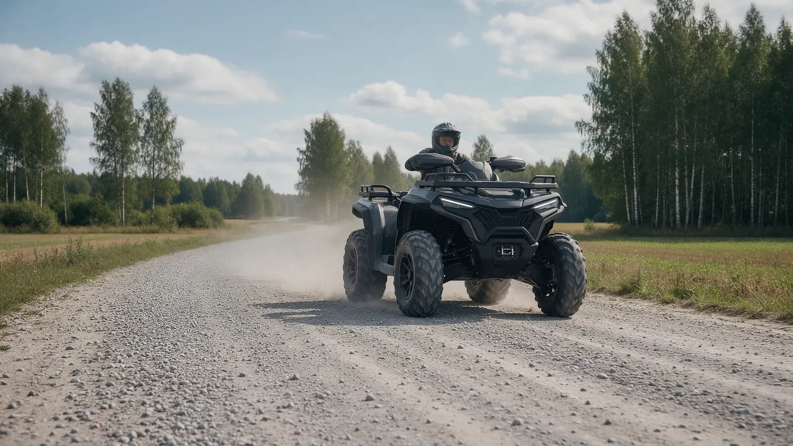 Vairuotojas su šalmu ant galingo keturračio žvyrkelyje